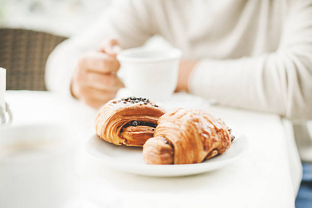 istock Man in a cafe having a coffee break with croissants 504854201