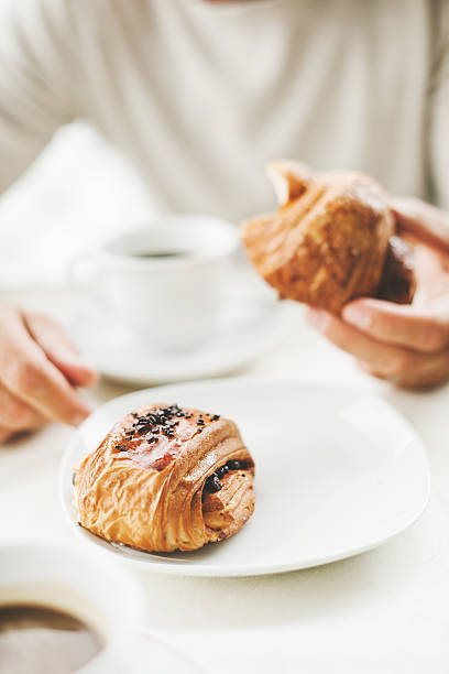 istock Man in a cafe having a coffee break with croissants 504854209