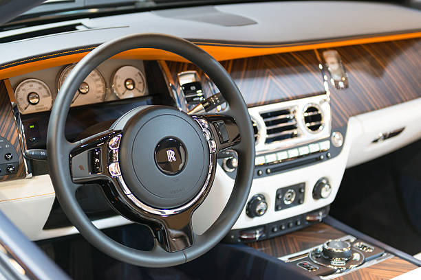 Rolls-Royce Dawn four seater luxury convertible dashboard Brussels, Belgium - Januari 12, 2016: Wooden dashboard on a Rolls-Royce Dawn luxury convertible automobile. The car is fitted with a twin-turbo 6.6-litre V12 and luxurious leather and wood interior. The car is on display during the 2016 Brussels Motor Show.  rolls royce stock pictures, royalty-free photos & images