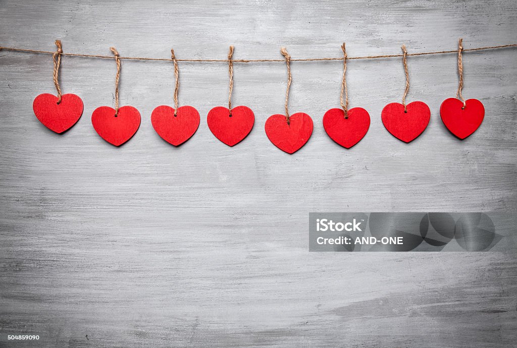 Love concept. Hearts hanging on a string Love concept. Hearts hanging on a string, shot on grey background Anniversary Stock Photo