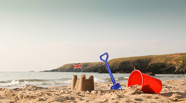 istock Beach, sea, bucket, spade and sandcastle with union jack 504859165