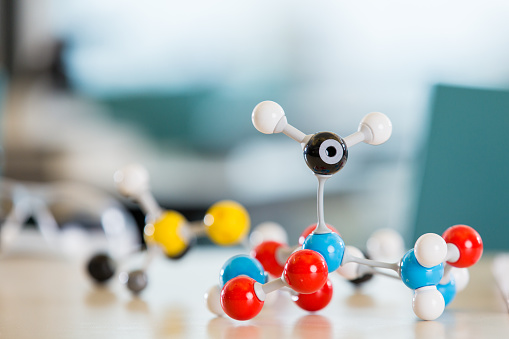 Educational model plastic toy molecules and atoms sitting on desk in private elementary school or middle school science lab classroom. Snap together plastic parts create molecule models.