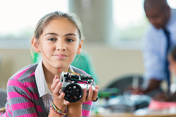 istock Hispanic elementary girl building robot during after school science club 504860064