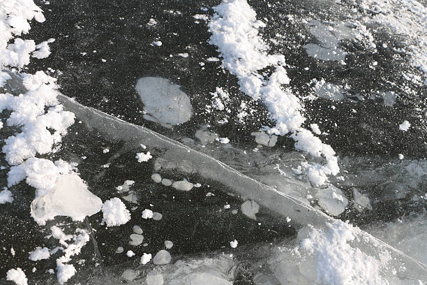 istock Crack and air bubbles under ice on the river 504860120
