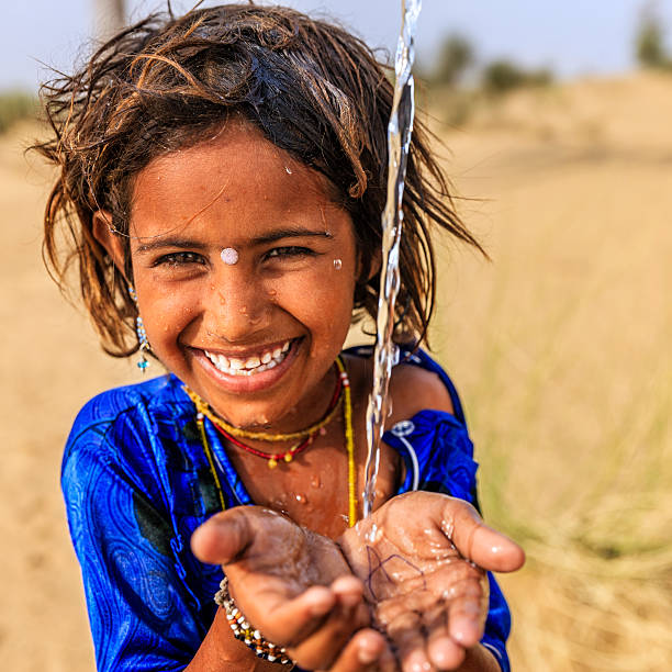 indische mädchen trinkt wasser, desert village, rajasthan, indien - poverty india child little girls stock-fotos und bilder