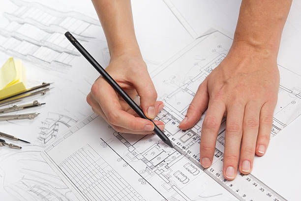 Architect working on blueprint. Architects workplace - architectural project, blueprints Architect working on blueprint. Architects workplace - architectural project, blueprints, ruler, calculator, laptop and divider compass. Construction concept. Engineering tools. autocad house plans stock pictures, royalty-free photos & images