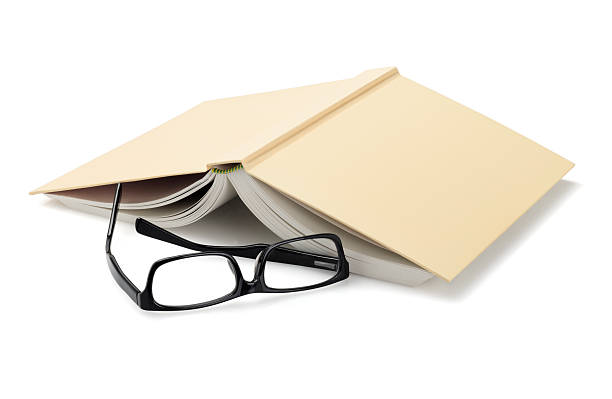 Spectacles Beside Inverted Book Spectacles Beside Inverted Book On White Background face down stock pictures, royalty-free photos & images