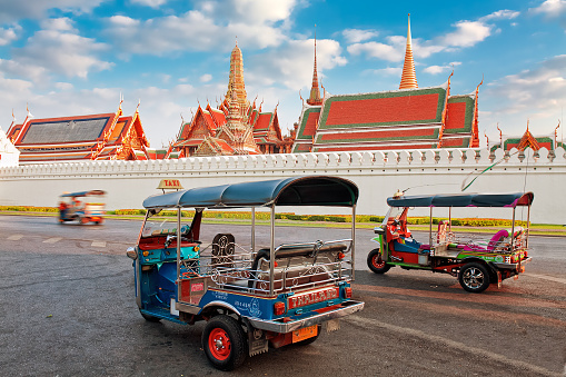 Bangkok, Thailand - March 3, 2014: Tuk Tuk taxi waits for customers about Temple of Emerald Buddha and home of Thai King in Bangkok