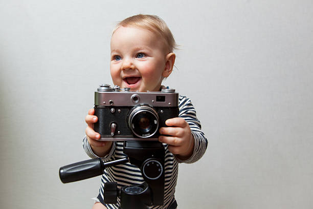 istock One year old baby boy with  camera 504863342