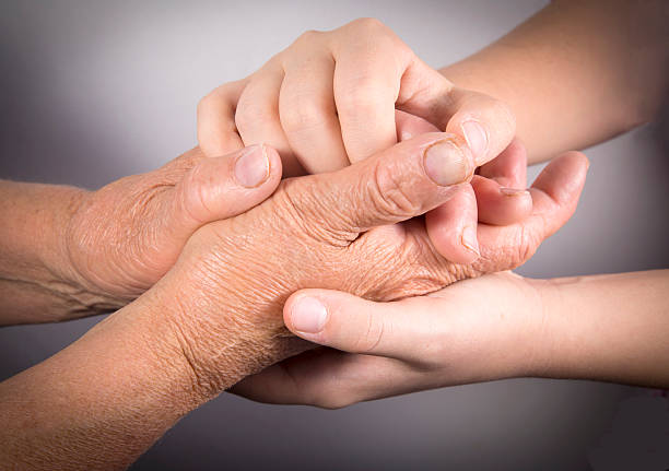 istock Two people holding hands for comfort 504865064