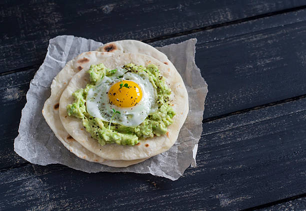 istock Homemade tortilla with mashed avocado and a fried quail egg. 504865342