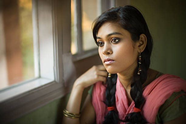 istock Serene girl looking away with blank expression sitting near window. 504866636