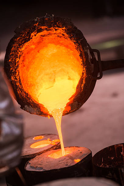 istock Foundry worker pouring hot metal into cast 504867024