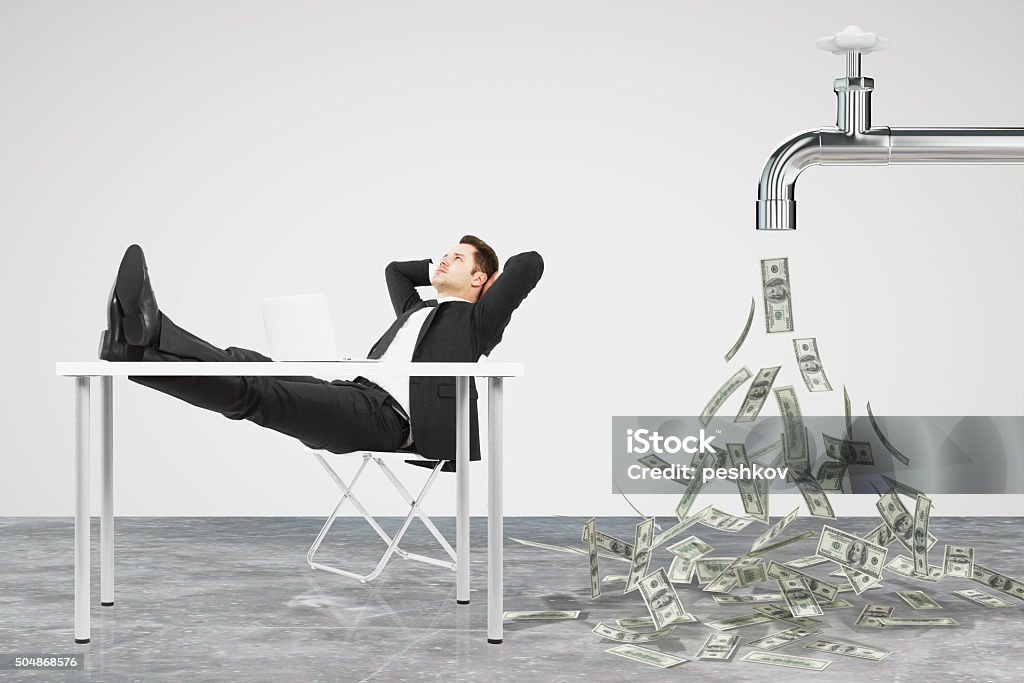 Businessman resting on a chair and faucet from Businessman resting on a chair and faucet from which the money flow Currency Stock Photo