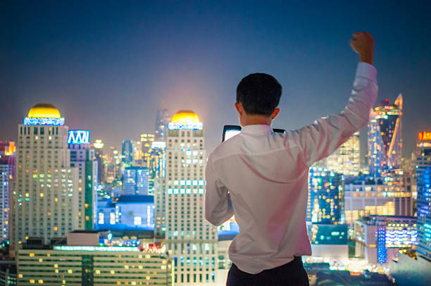 istock Businessman using a laptop on the rooftop of a skyscraper 504875686