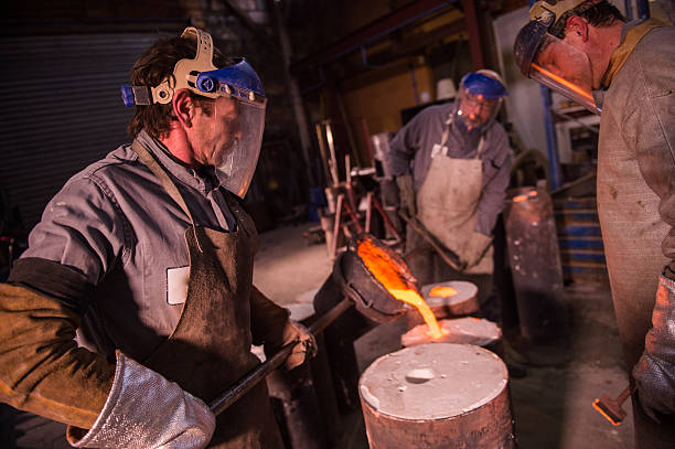 istock Foundry worker pouring hot metal into cast 504876704