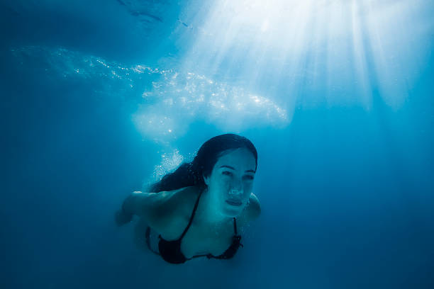 istock Girl Swimming Underwater Under Bright Sunrays 504877916