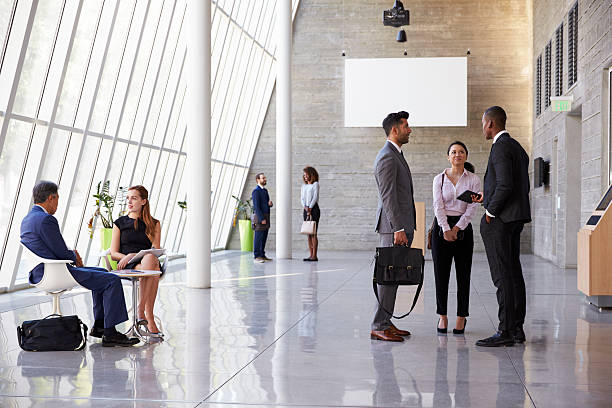 Interior Of Busy Office Foyer Area With Businesspeople Interior Of Busy Office Foyer Area With Businesspeople lobby stock pictures, royalty-free photos & images
