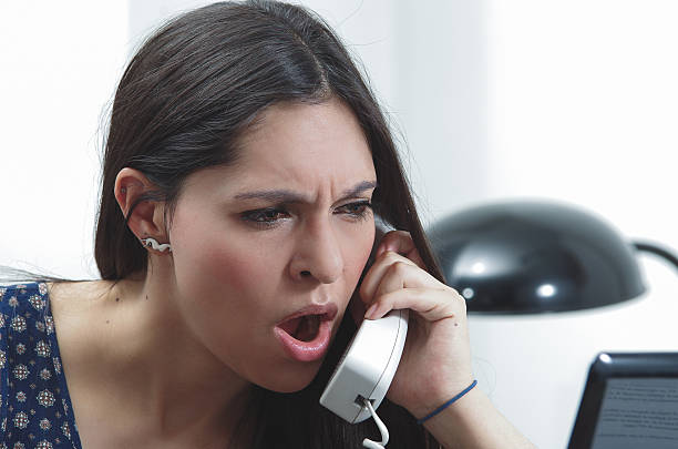istock Hispanic brunette sitting by office desk talking on telephone with 504880130
