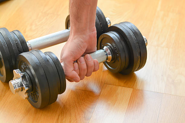 istock Young man doing exercises with dumbbells at home 504880666