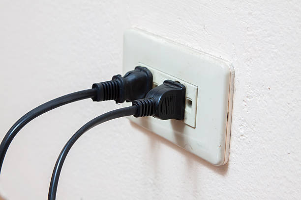 istock hand pluging cable to the electric outlet 504881258