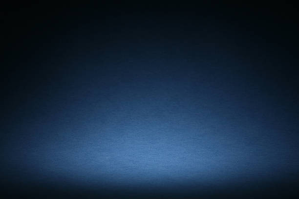 Blue Sweep Background With Vignette Blue background image made with curved paper and halo style vignette lighting. Ideal for the designer to add floating copy, objects with drop shadows. Selective focus on the lightest area of the halo navy blue photos stock pictures, royalty-free photos & images