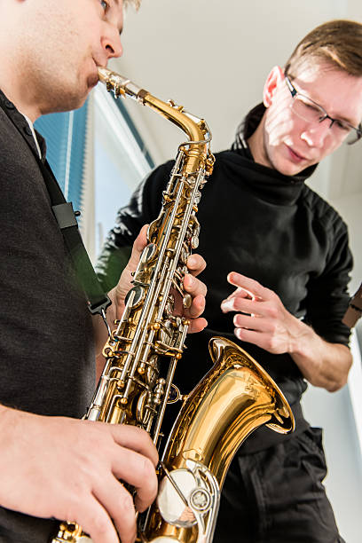 istock Young Man Learning to Play Saxophone at Home 504882848