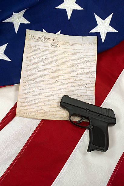 istock Constitution with Hand Gun on American Flag, Vertical 504884178