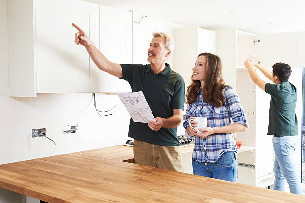 istock Woman With Carpenter Looking At Plans For New Kitchen 504884766