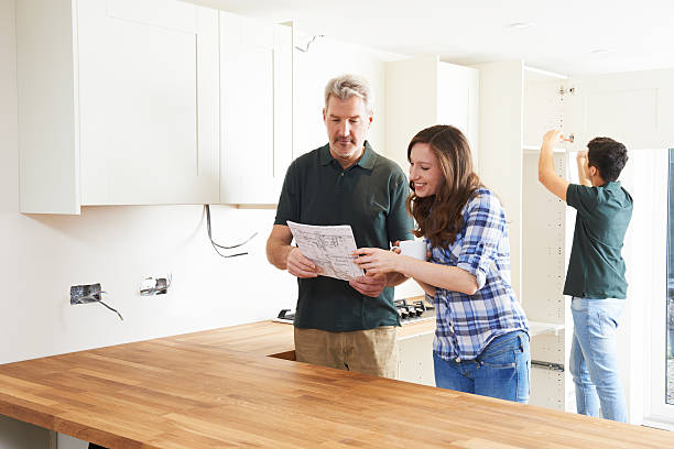 istock Woman With Carpenter Looking At Plans For New Kitchen 504884870