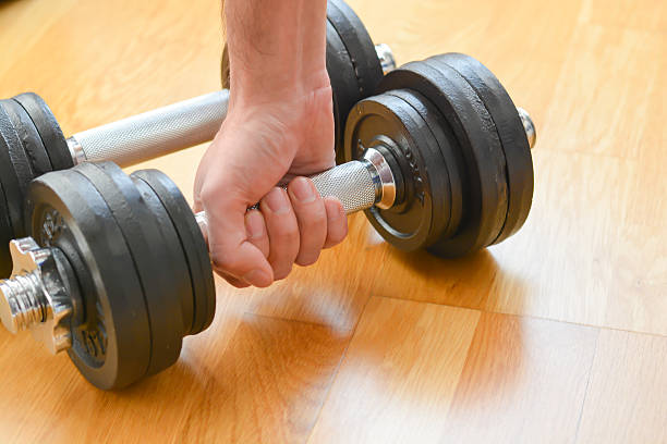 istock Young man doing exercises with dumbbells at home 504884986