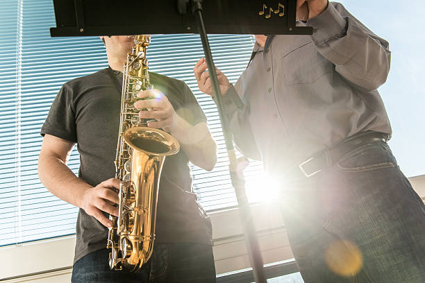 istock Young Man Learning to Play Saxophone at Home 504885408