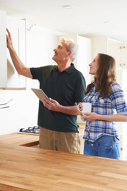 istock Woman With Carpenter Inspecting New Fitted Kitchen 504885594