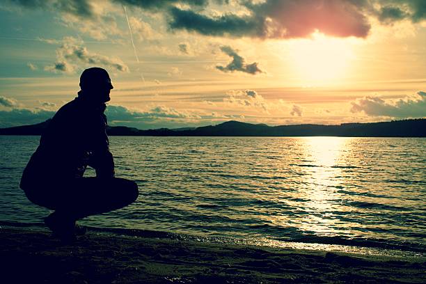 istock Man stand near beach looking at sunset, peaceful water level 504885642