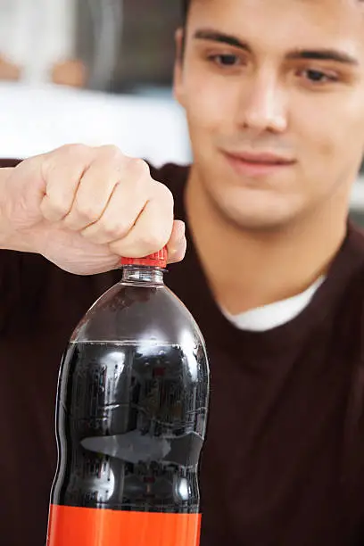 Photo of Young Man Opening Bottle Of Soda