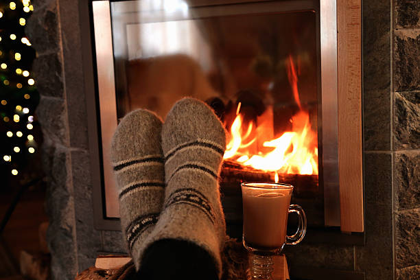 istock Feet in wool socks warming at the fireplace 504887758