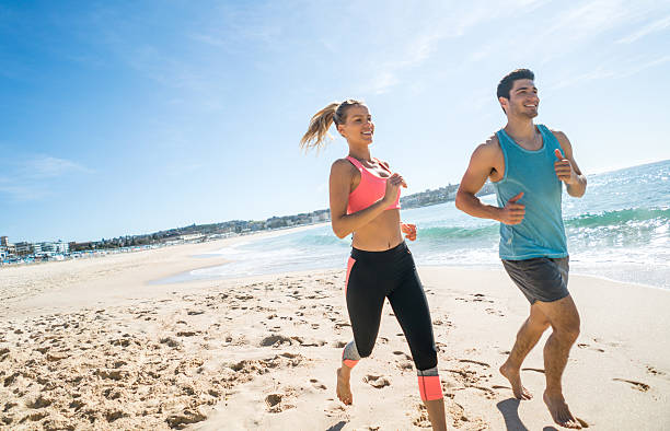 istock Athletic couple running at the beach 504887772