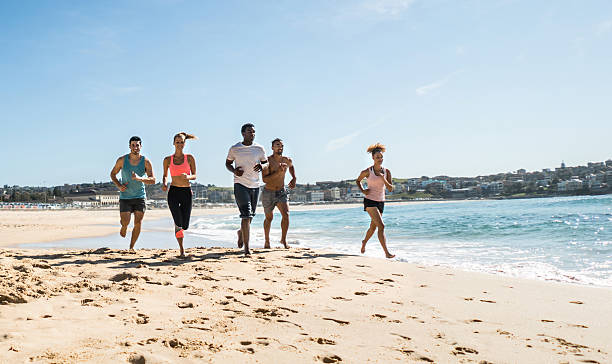 istock Athletic group of people running at the beach 504887840