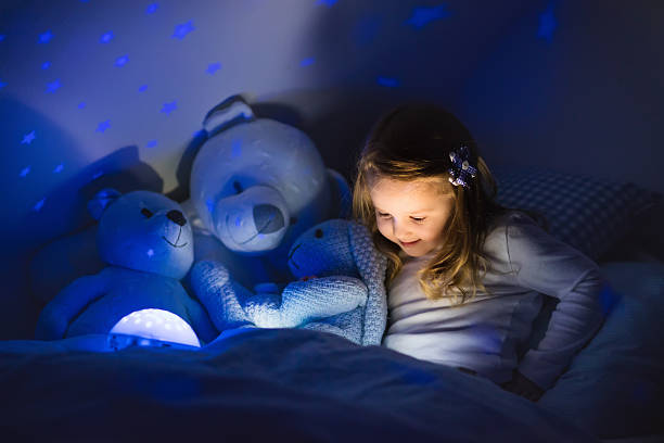 istock Little girl reading a book in bed 504891508