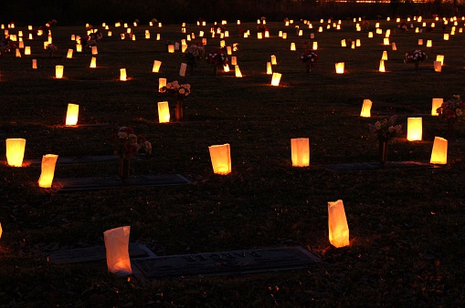 Luminaries lit and scattered throughout the cemetery.  These are made from candles and placed in paper bags.  They are placed here in the memory of people who have passed away.