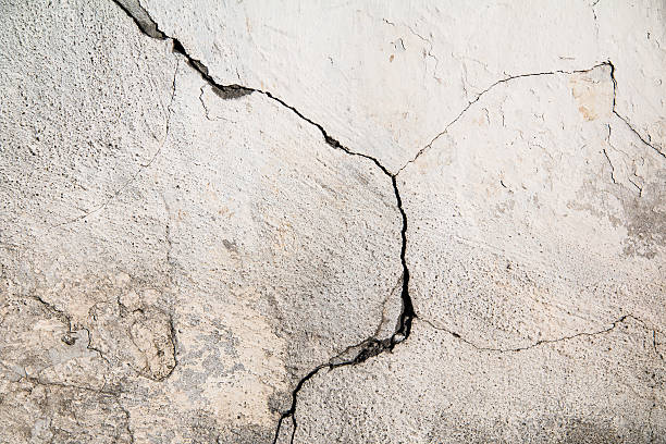istock Crack. Texture of old painted white plaster. Cracked wall. 504892056
