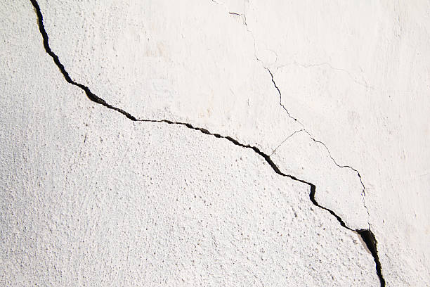 istock Crack. Texture of old painted white plaster. Cracked wall. 504892070