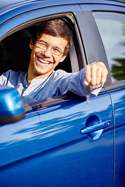 Rapaz no carro com chave - fotografia de stock