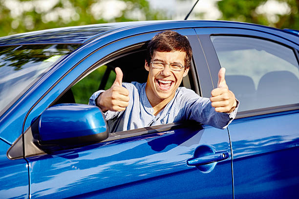 Homem mostrando os polegares para cima no interior de carro - fotografia de stock