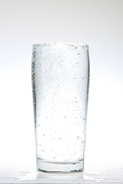Bubbly club soda water in a glass freshly poured so bubbles and water is still turbulent.