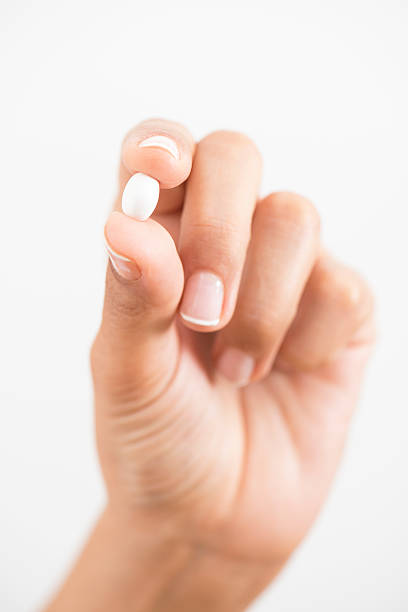 Close up of pill in female hand.