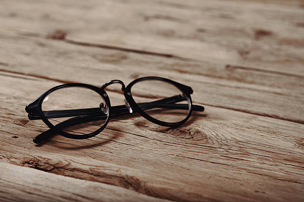 istock black reading glasses on wooden background 504899436
