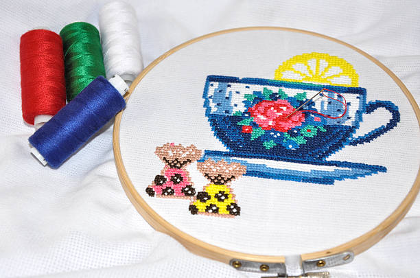 Female hand embroiders in the hoop under lamp light