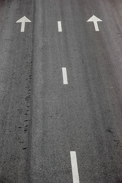 istock arrow symbol and white stripes on asphalt road 504907087