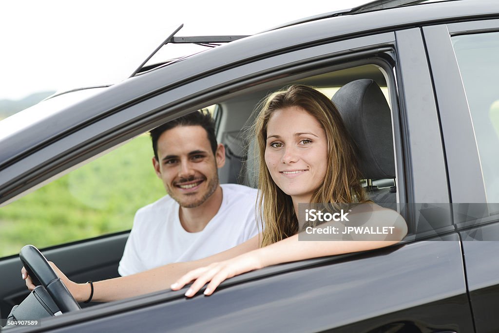 happy cheerful young couple driving new car holiday trip summertime happy and cheerful young couple driving new car during holiday trip in summertime in countryside Adult Stock Photo